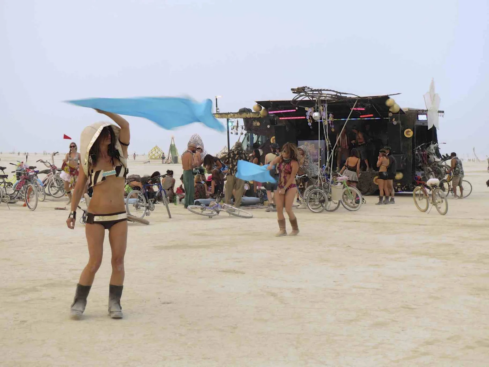 Attendees in playa costumes dancing in the deep playa at Burning Man