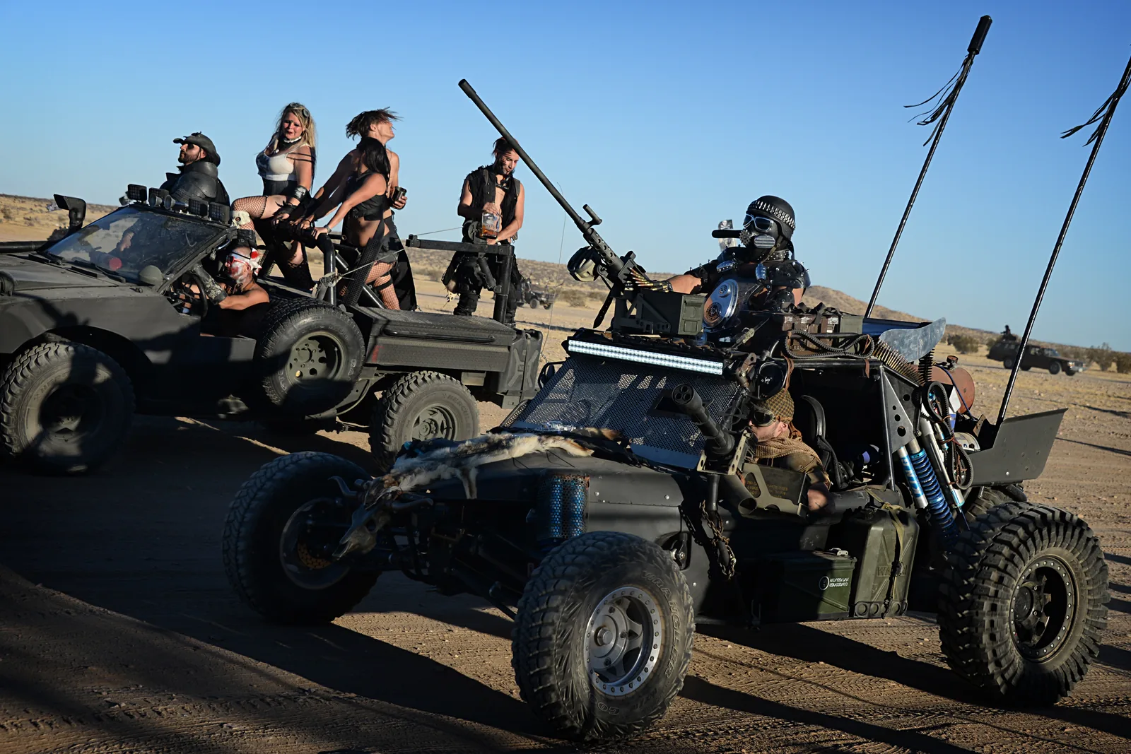Custom post-apocalyptic vehicles lined up at the Wasteland Weekend car show in the Mojave Desert