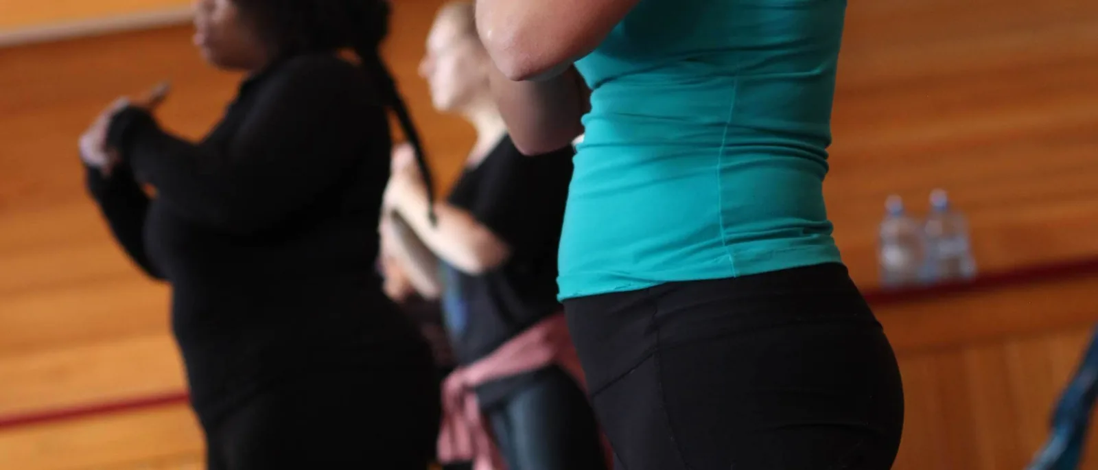 Standing practitioners mid-class at a Big Bear Yoga Festival indoor session