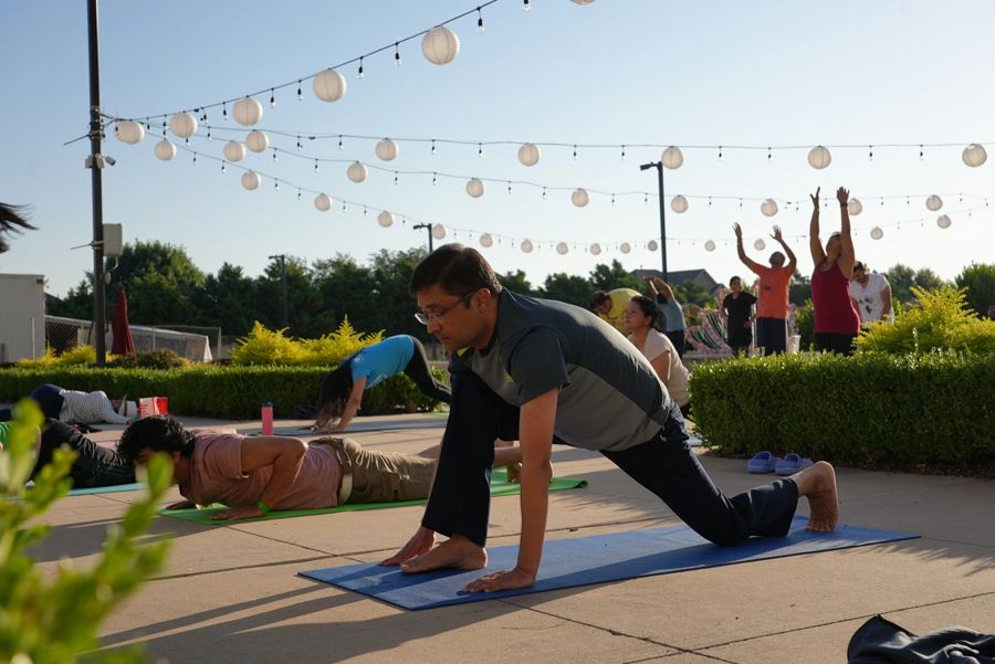 Sunrise surya namaskar practice under paper lanterns at Dallas Yoga Fest