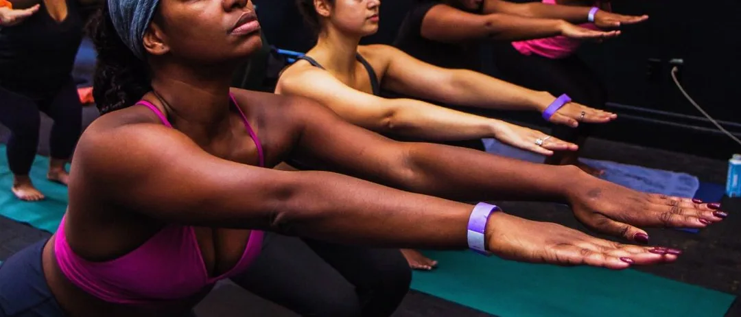 Chair-pose rows with arms extended at a Dirty South Yoga Fest class in Atlanta