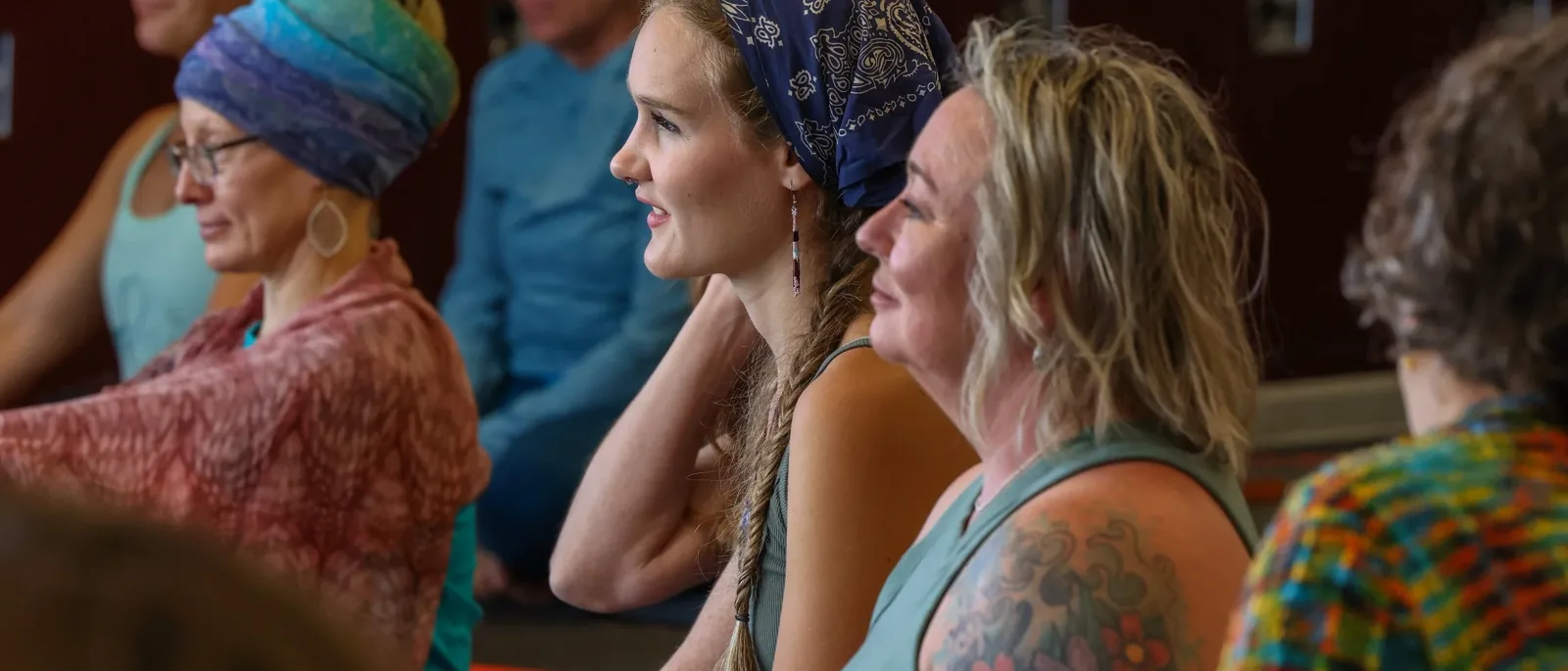 Seated audience in colorful festival wear at Grand Valley Yoga Fest