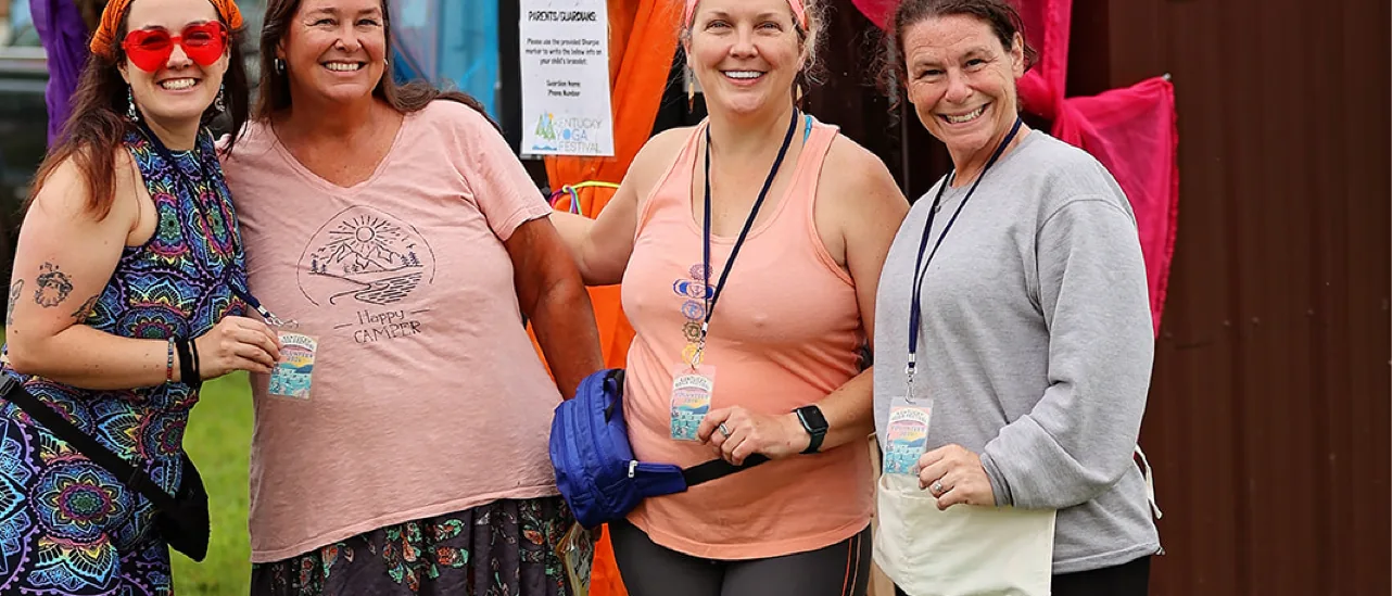 Volunteers smile outside the silk-draped welcome hut at Kentucky Yoga Festival