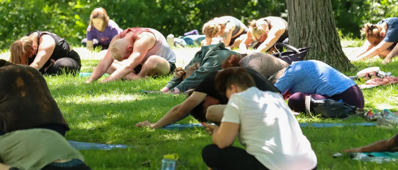 Child's pose under the park canopy at Mandala Yoga Festival