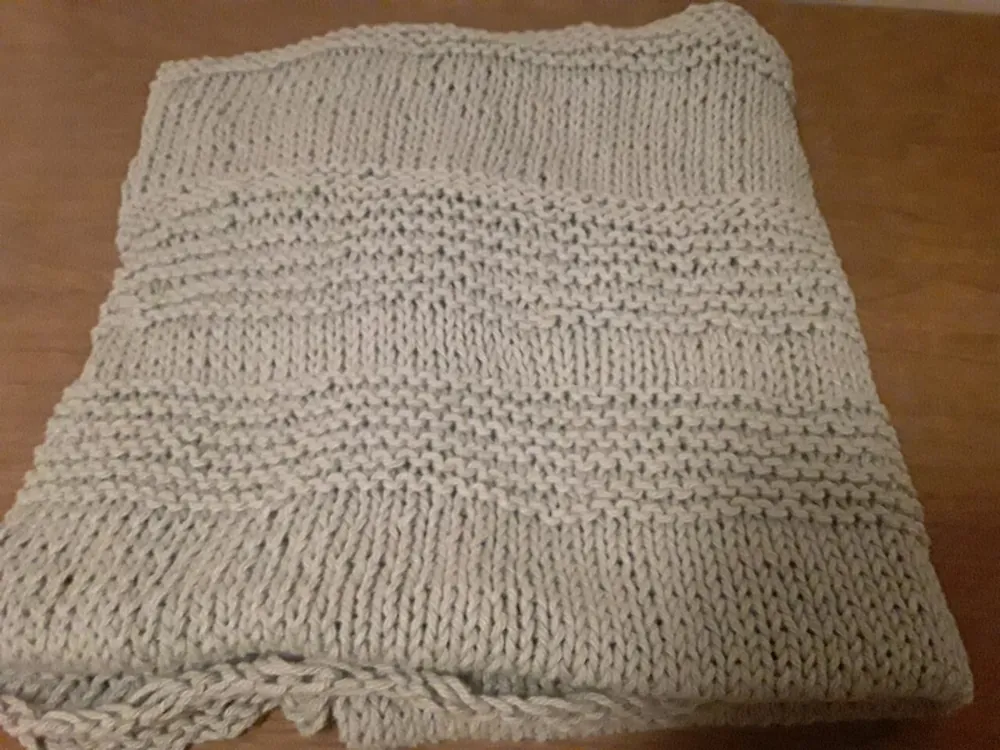 Folded grey knitted blanket