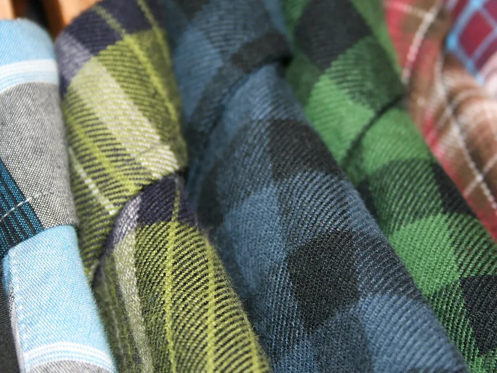 Stack of folded flannel shirts in blues and greens