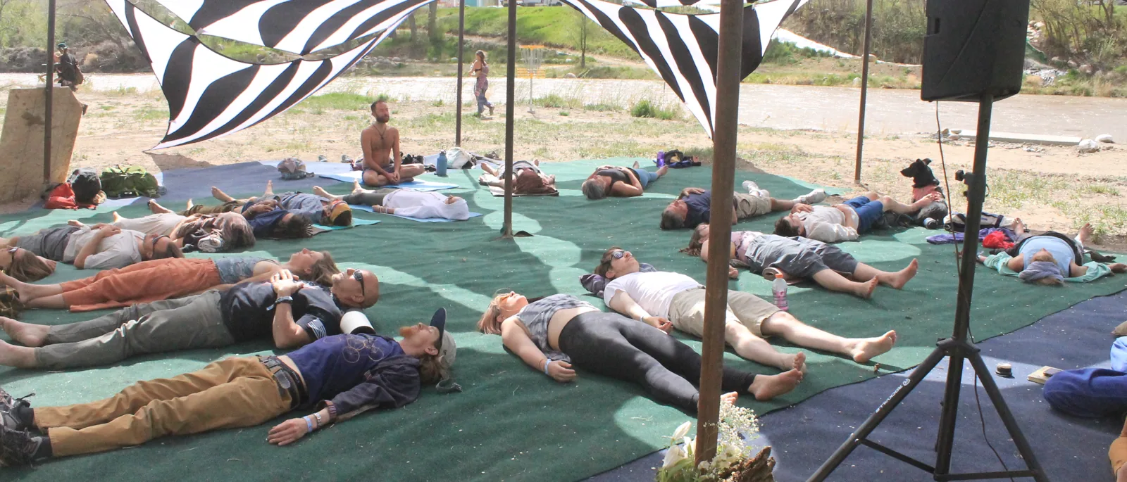 Savasana under the black-and-white riverside canopy at Sangha Yoga Fest