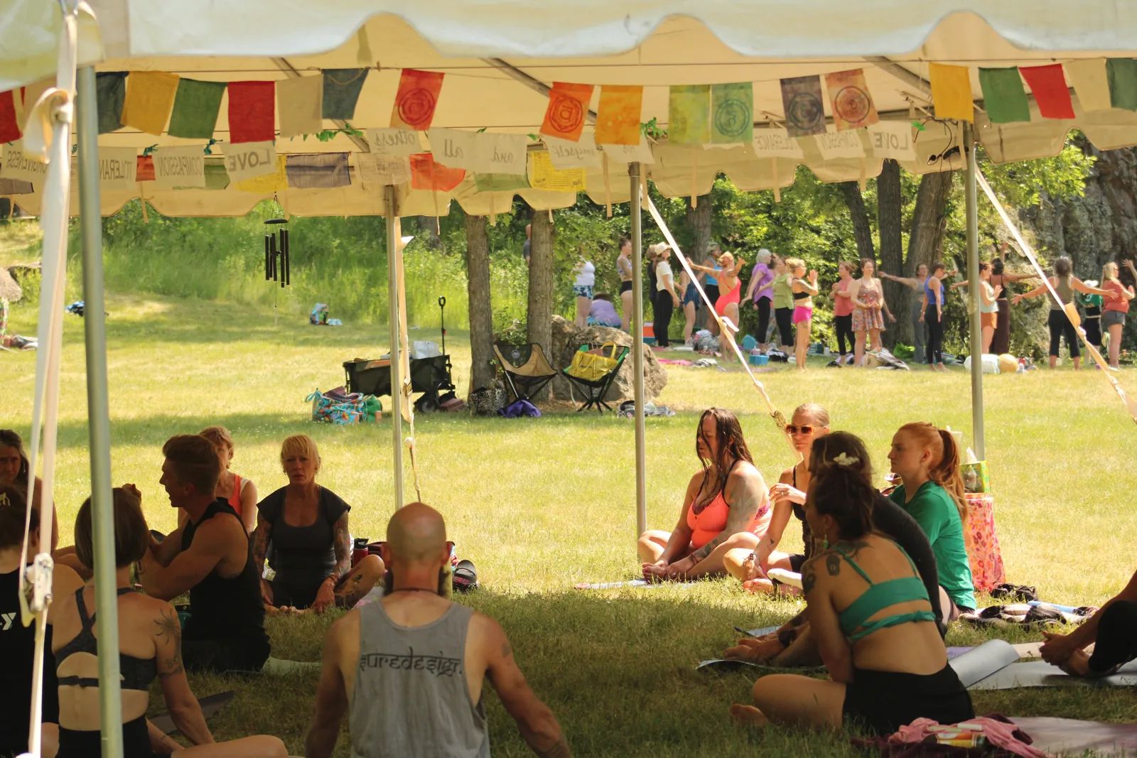 Prayer flags ring the meadow tent as classes flow at the South Dakota Yoga Gathering