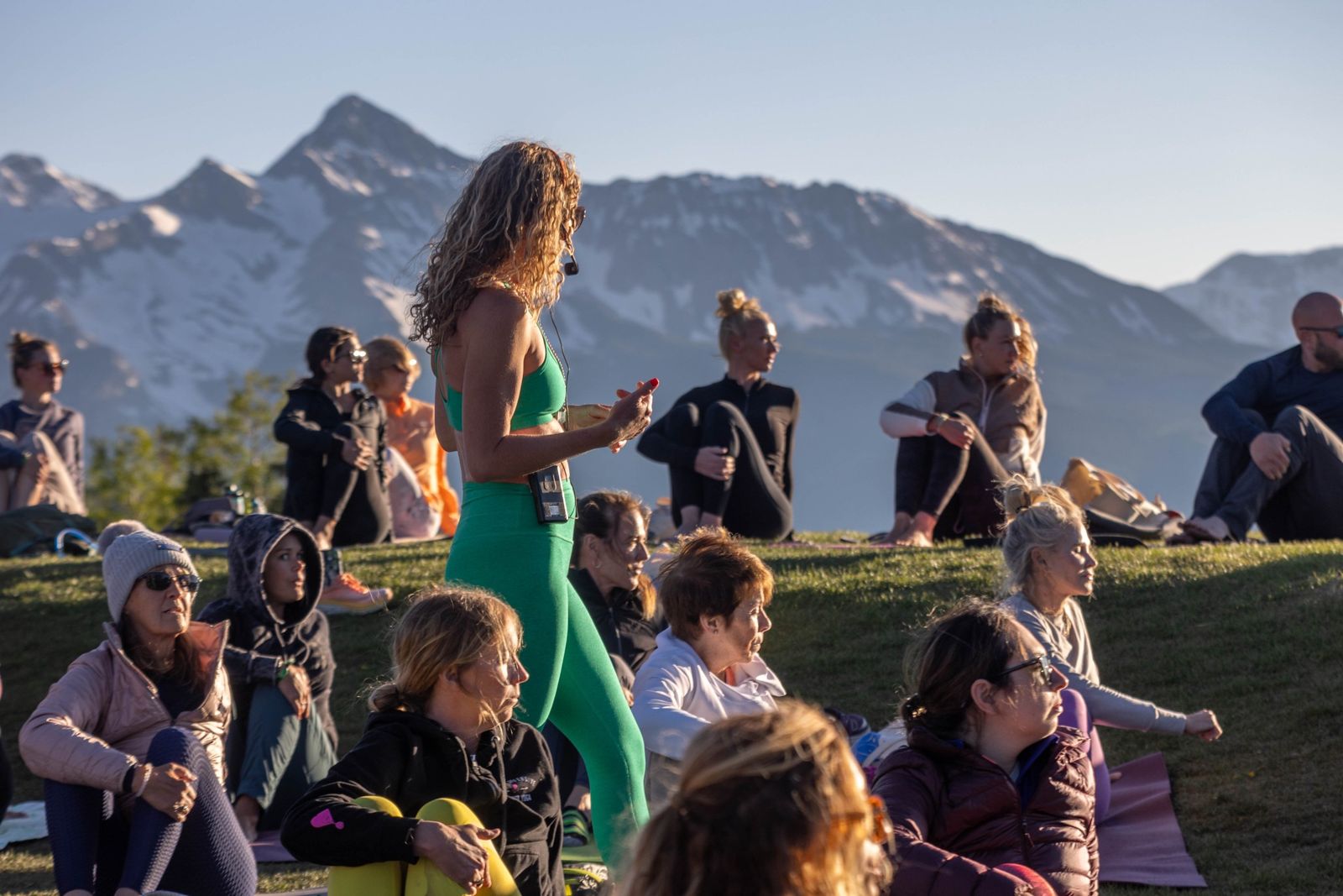 Instructor leading an outdoor class before the snow-capped San Juan mountains at Telluride Yoga Festival