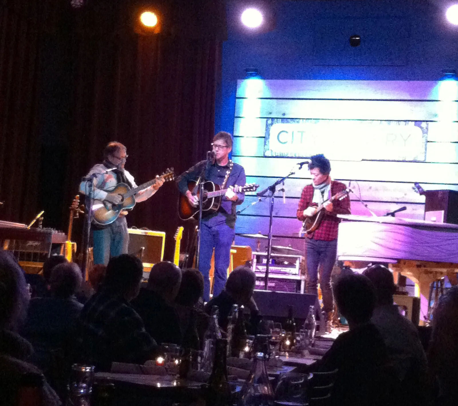 A band on the stage at City Winery Nashville, seen from the tables