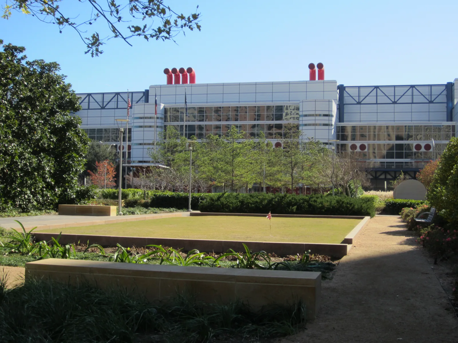 Lawn and planted beds at Discovery Green with the convention center behind