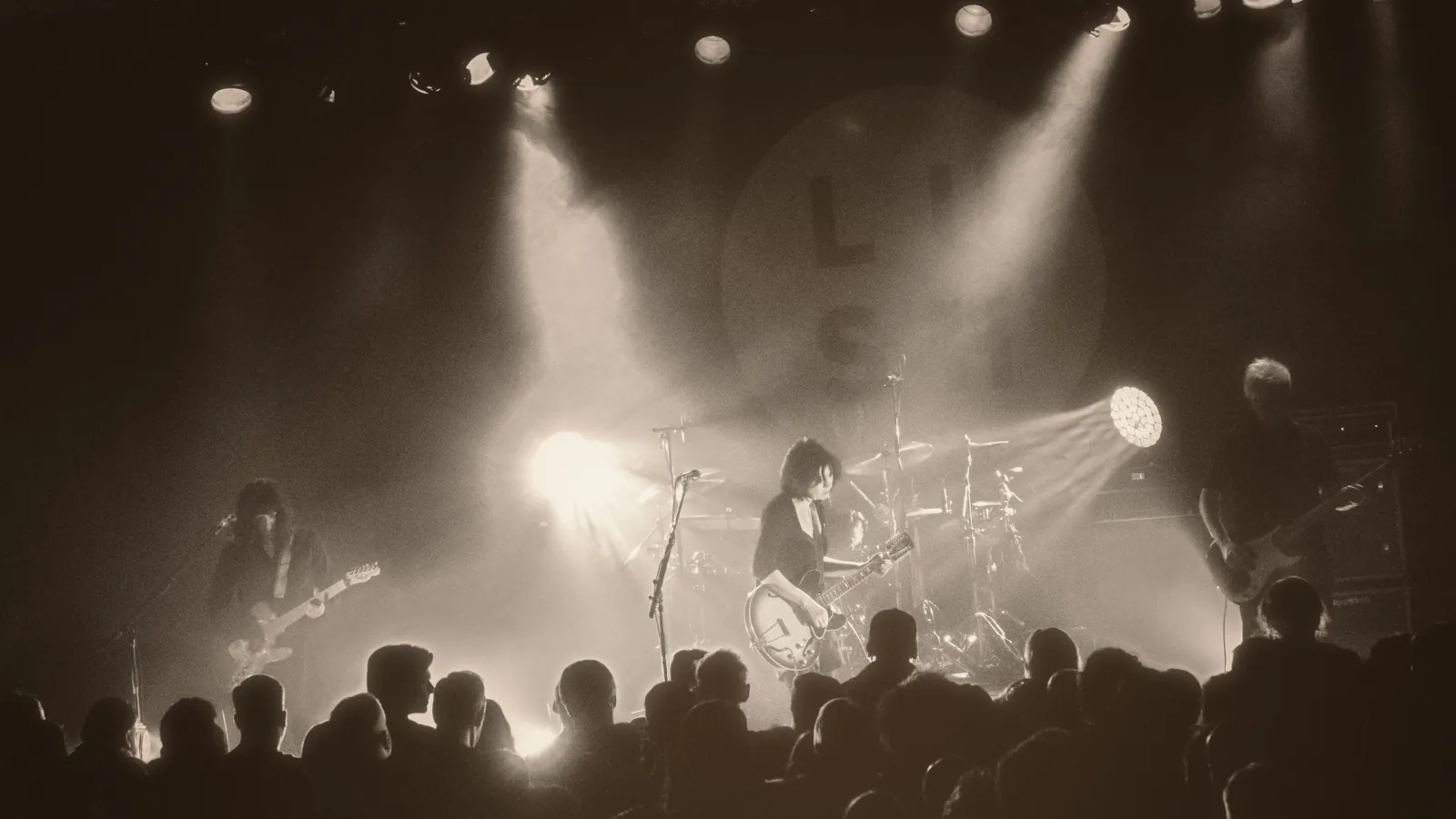 A crowd facing the lit stage inside The Showbox, Seattle